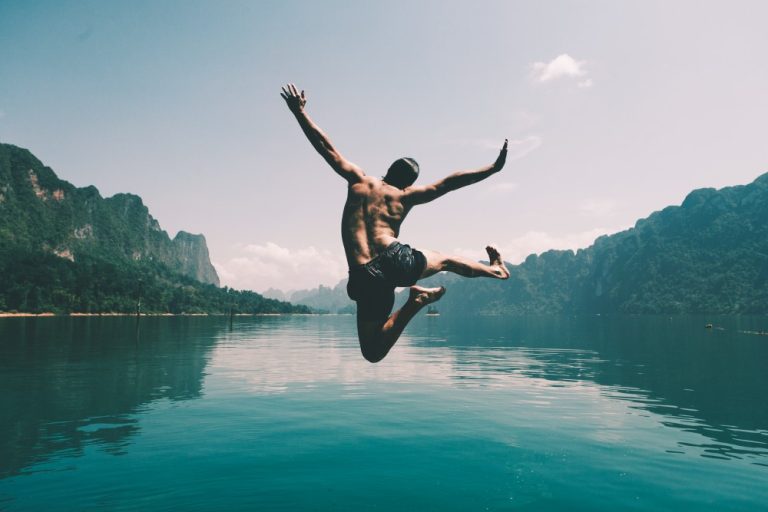 man-jumping-with-joy-by-lake (1)
